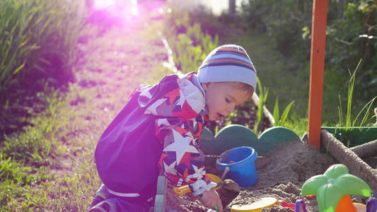 孩子玩的玩具在沙箱中。夏天阳光灿烂的日子。娱乐和游戏户外