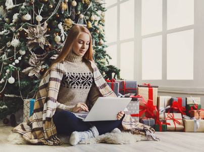 在温馨的圣诞装修在线购物的年轻女人