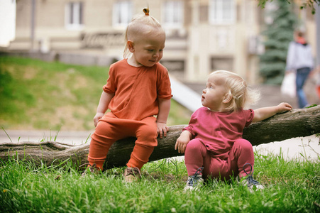 男婴和女婴玩耍时坐在绿色的草地上