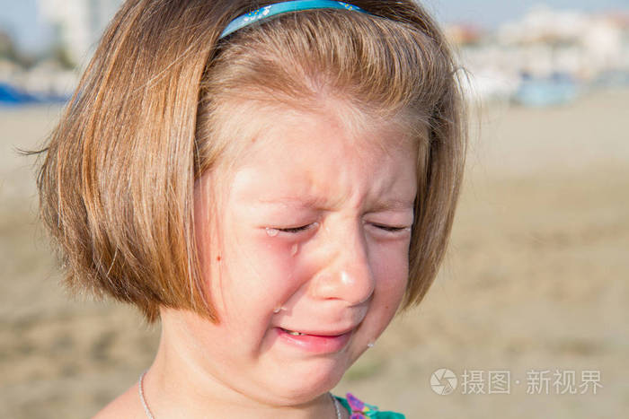 在沙滩上哭泣的小女孩