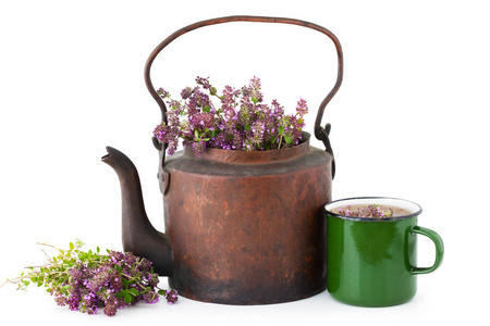 复古仿古茶水壶满百里香鲜花，搪瓷的杯健康凉茶和白色背景上的百里香束。中药