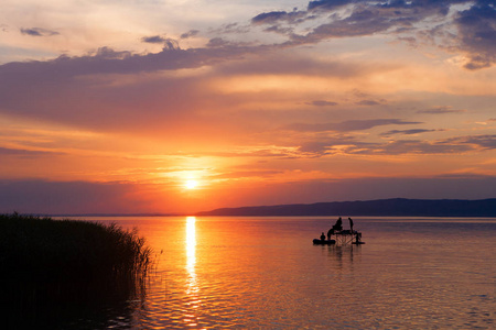 与钓鱼的剪影在匈牙利巴拉顿湖落日