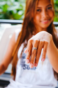 年轻漂亮的女孩，显示她的银戒指的手