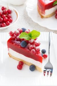 一块芝士蛋糕与浆果果冻在白盘子里，顶视图