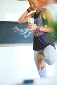 竞技运动美女瑜伽锻炼后的喝蛋白质奶昔。女人。瑜伽