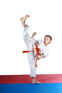 在 karatege 中的男孩正在踢高腿腿