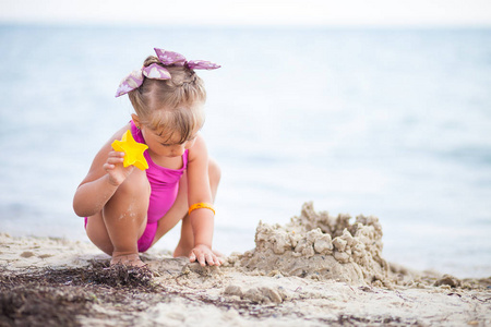 小女孩在沙滩上建造一座沙堡