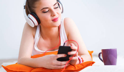 年轻女子躺在地板和听音乐