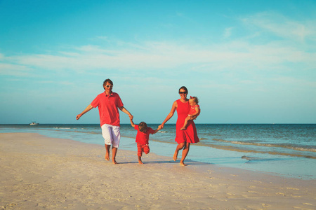 在海滩上玩耍的两个小孩的家庭