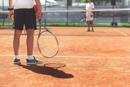 年轻男性的孩子准备好网球