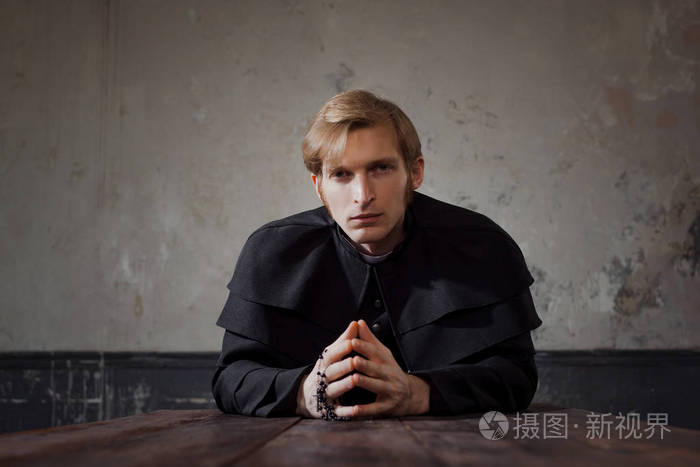 画像的英俊年轻的天主教神父向上帝祈祷黑暗的风格概念怀疑