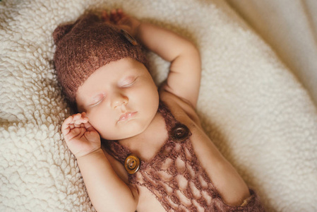 刚出生的婴儿婴儿男孩睡在一张毛茸茸的毯子上。在针织帽子婴儿甜甜地睡觉