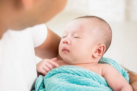 在父亲怀里睡觉的可爱新生婴儿