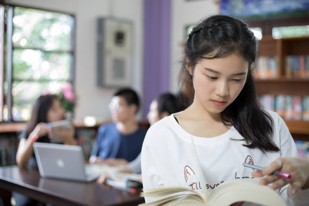 亚洲女学生选择抱着书在图书馆图片