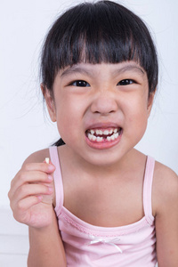 亚洲中国小姑娘抱着她的牙缺失