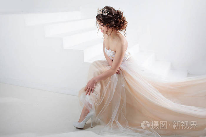 一个漂亮的女孩穿着婚纱的画像.跳舞的新娘,白色背景