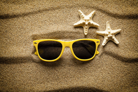 黄色的太阳镜和沙滩上的海星