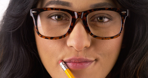 可爱的墨西哥女人，戴着眼镜和咬铅笔