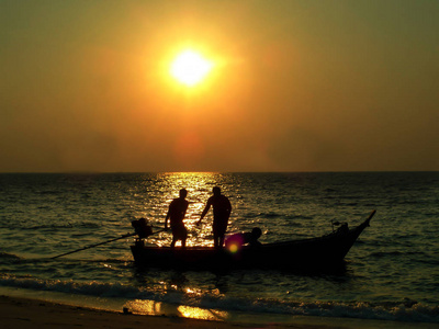 两个渔夫捕鱼船和日出海上