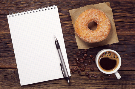 笔记本和杯咖啡与甜甜圈