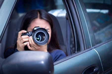 年轻女人跟踪和用她的相机，她的车内拍照