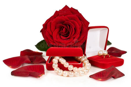 红色礼品盒中的珍珠项链和耳环，带有玫瑰和花瓣