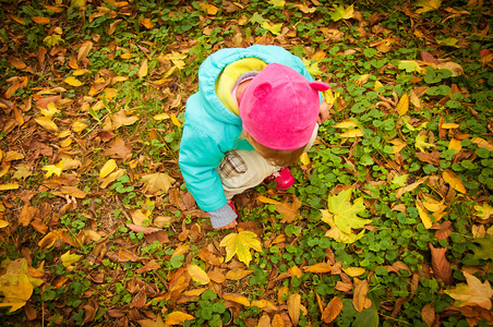 可爱的孩子走在秋天的公园