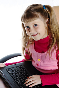 微笑女孩与便携式计算机