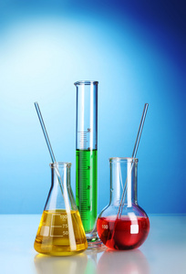 同颜色的液体与反射在蓝色背景上的三个烧瓶