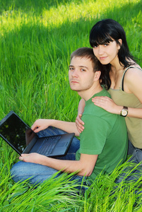 年轻夫妇与室外的笔记本电脑