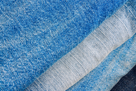 堆栈的各种色调的蓝色牛仔裤长裤作为纹理或背景