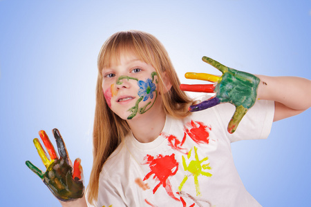 漂亮的小女孩用手绘多彩涂料中