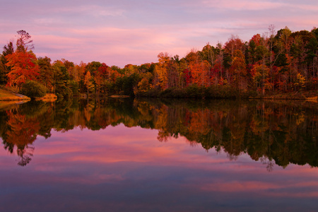 森林湖四周树木与秋天的颜色在黄昏时