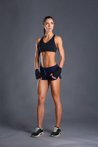 肌肉构成的运动服在黑色背景下的年轻女子