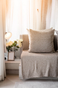 在阳光明媚的日子里，客厅的当代内部有部分沙发和白色窗帘的内部背景概念