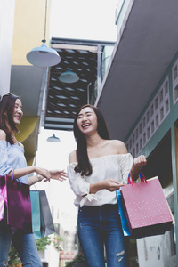 在百货商店的彩色购物袋幸福亚洲女人