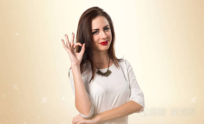 年轻漂亮的女孩制作 ok 的手势