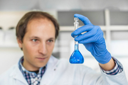 男性的实验室的研究员执行测试与蓝色的液体