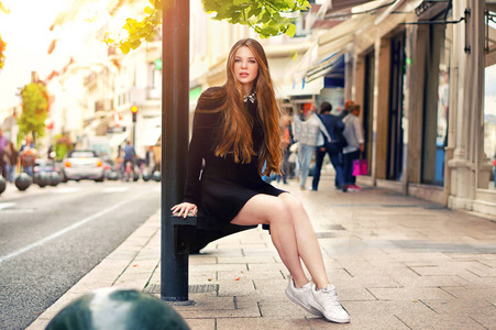 年轻漂亮的时髦的白人女孩摆在欧洲的城市