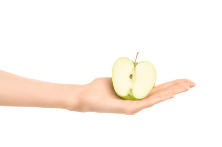 健康的饮食和饮食主题 人类的手，握著孤立在工作室里的白色背景上的半青苹果