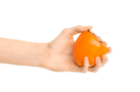 健康的饮食和饮食主题 人类的手，握著成熟的柿子，孤立在工作室里的白色背景上