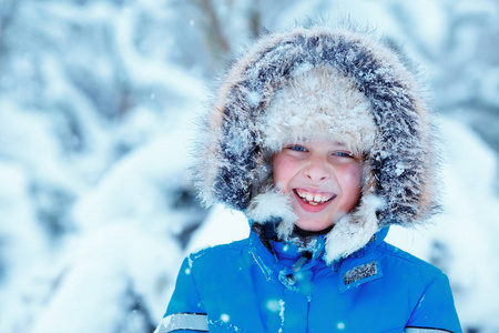 可爱的小男孩，穿着暖和的衣服，在冬天森林上玩