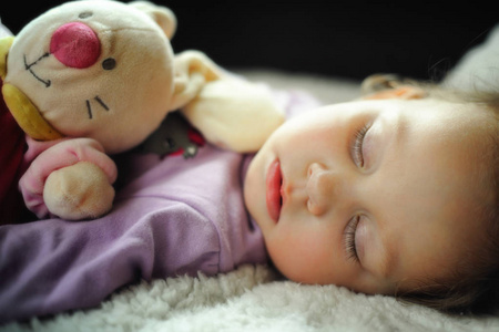 可爱的小女孩睡着玩具和糖果拐杖