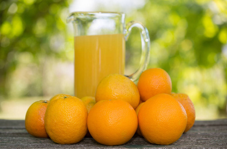 美味的橙汁和在花园里的桌子上的橘子