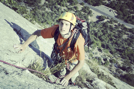 宽阔的山谷的背景与石灰石墙上爬的岩石 Climber.Young 人