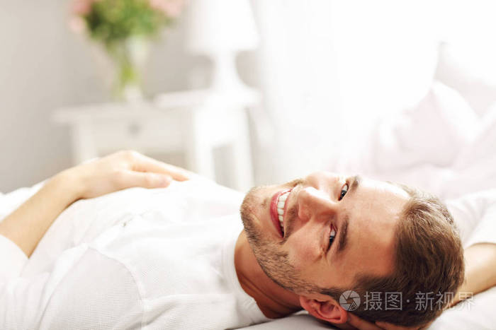 英俊的男人躺在床上