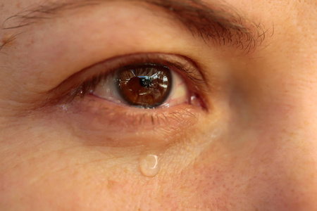 含泪的眼睛的特写.在女人的眼滴泪.伤心的女孩哭泣照片