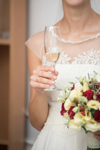 新娘举行婚礼的花束和一杯香槟