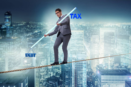 债务和税收之间平衡的商人图片