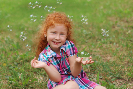 小女孩认为泡沫在草丛之中，气泡中夏公园